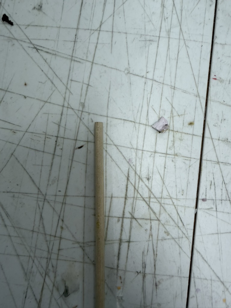 Non-sanded wooden rod with a flat bottom edge