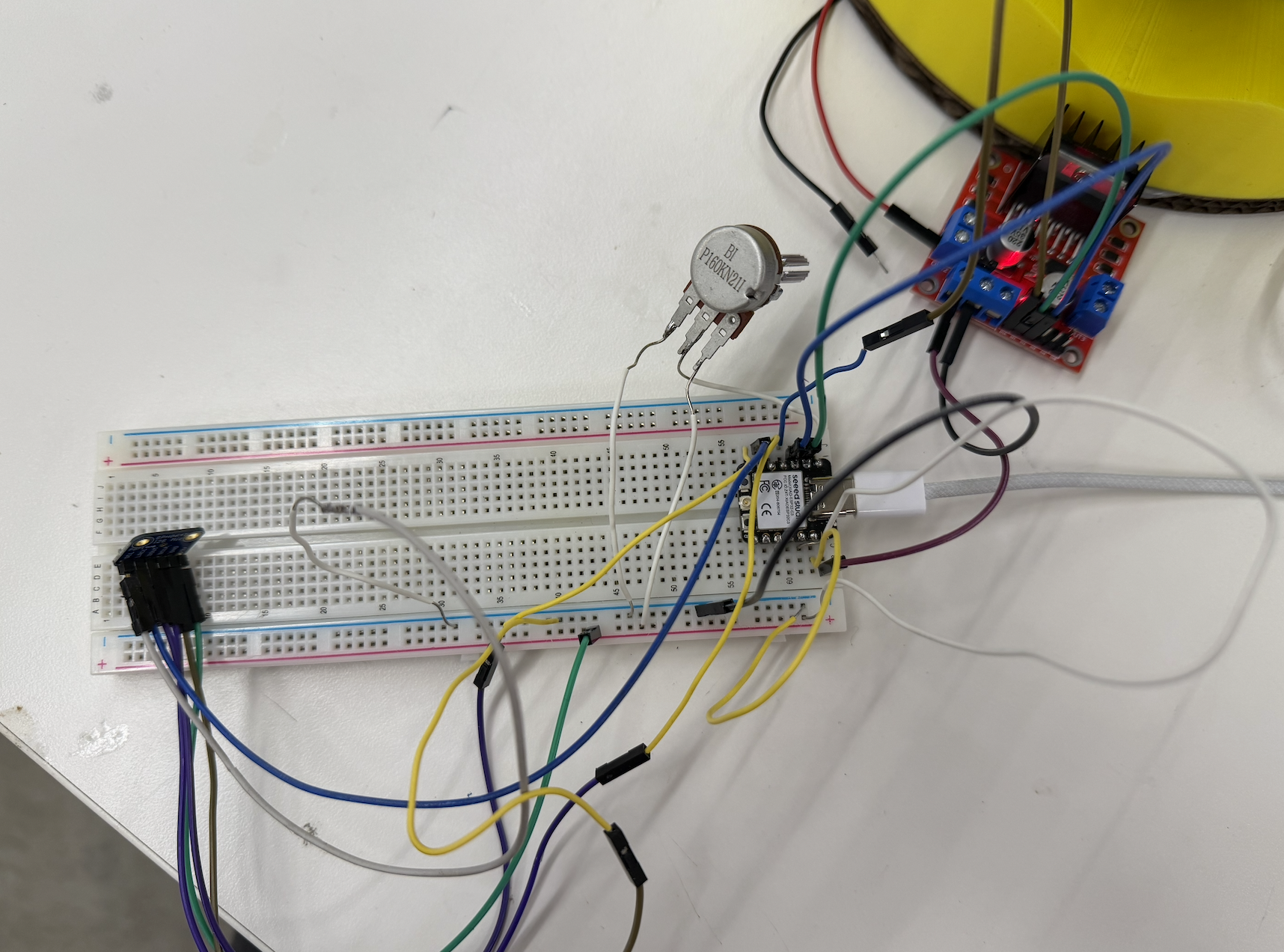 Breadboard wiring showing the XIAO microcontroller connected to a potentiometer, motor driver, and Adafruit I2S microphone