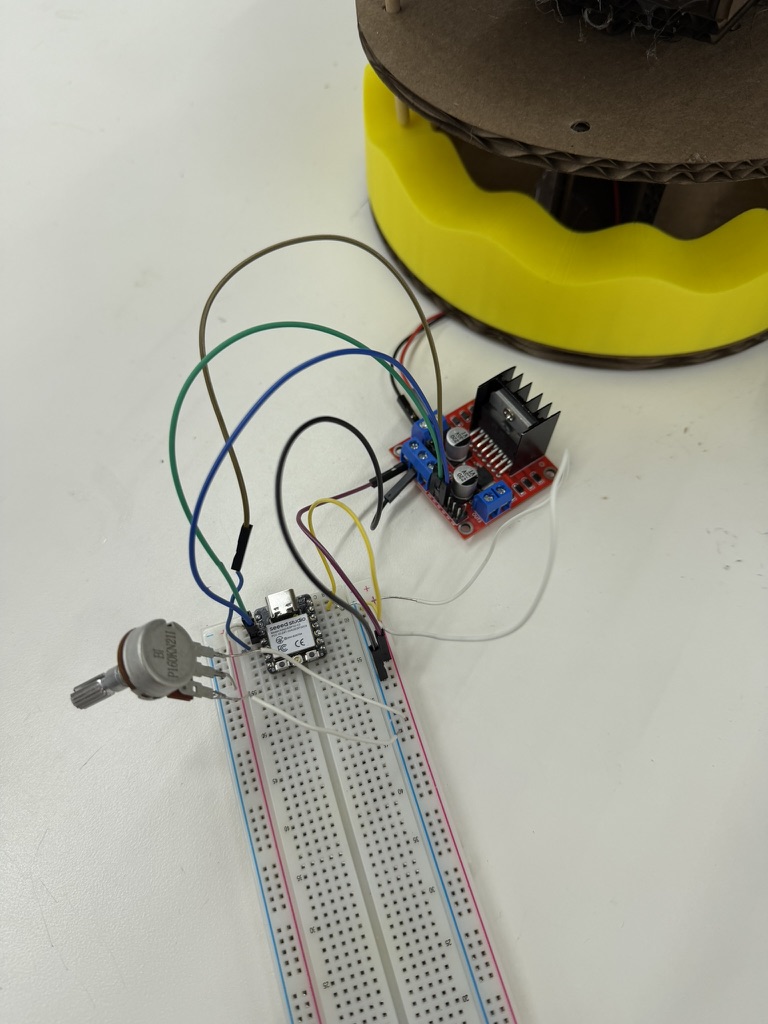 XIAO microcontroller on a breadboard wired to a motor driver and potentiometer for carousel control