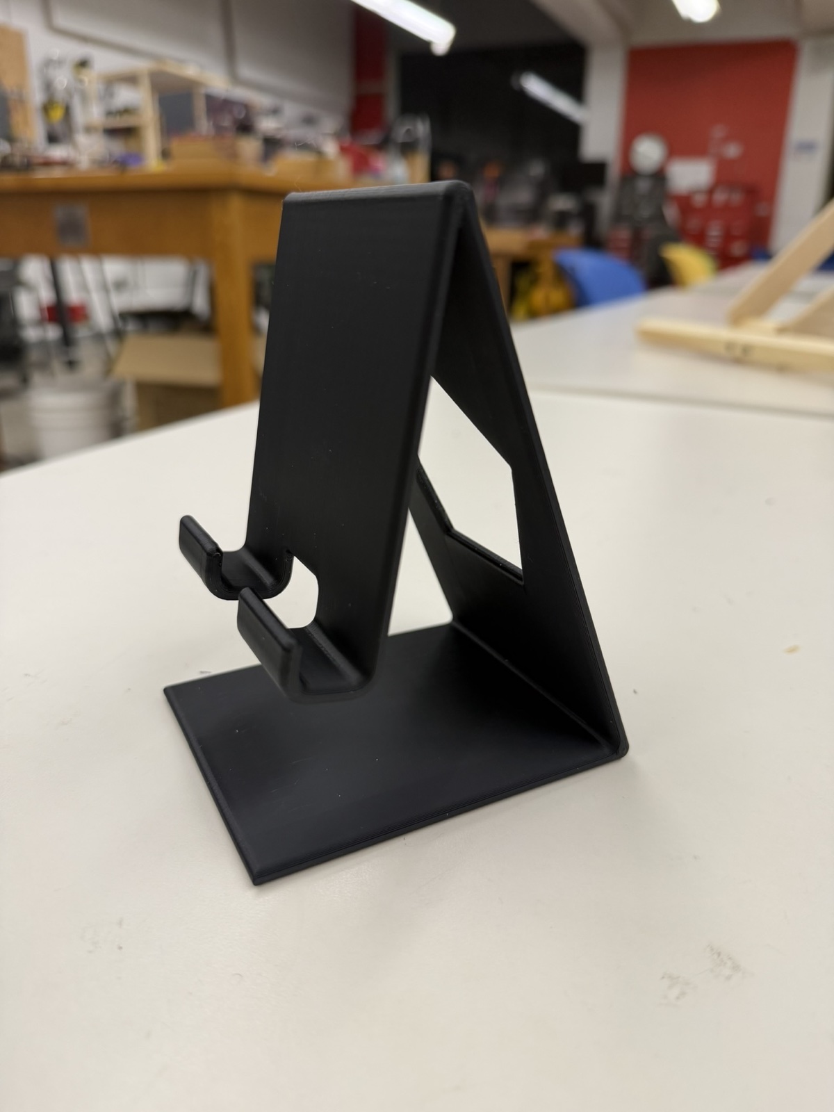 Finished black 3D printed iPhone stand on a lab table