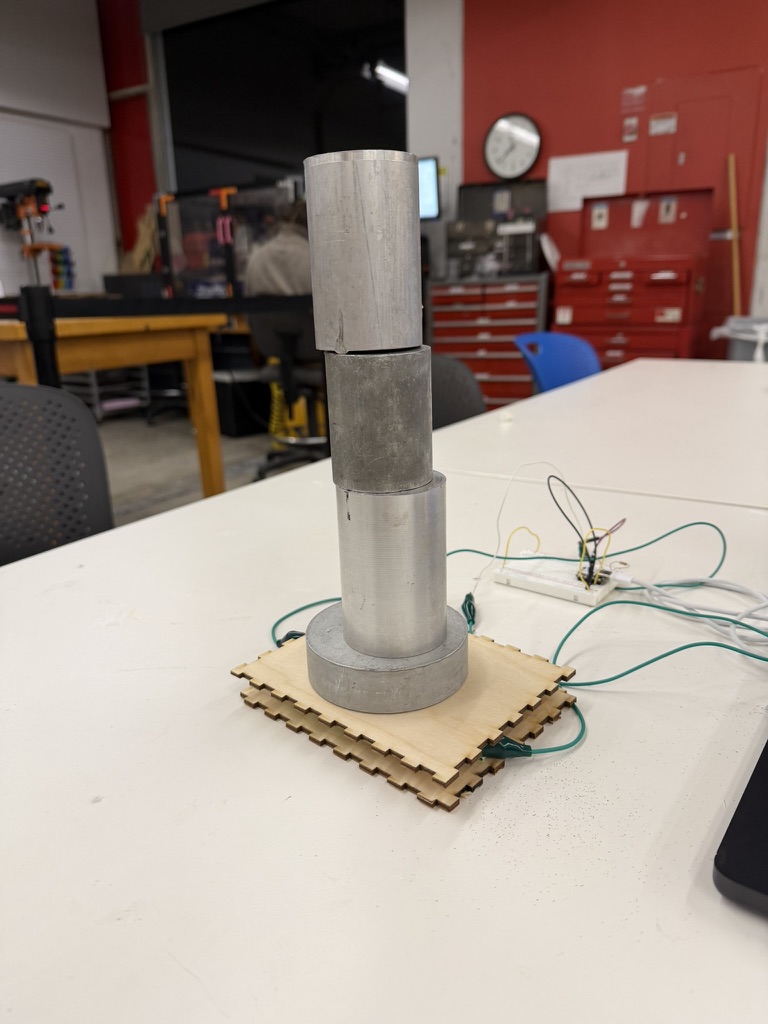 A taller stack of scrap metal pieces placed on the capacitive weight sensor for calibration