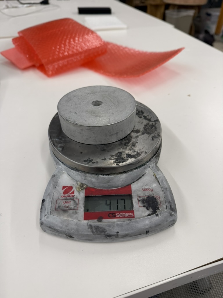 Scrap metal pieces being measured on a scale for capacitive weight sensor calibration