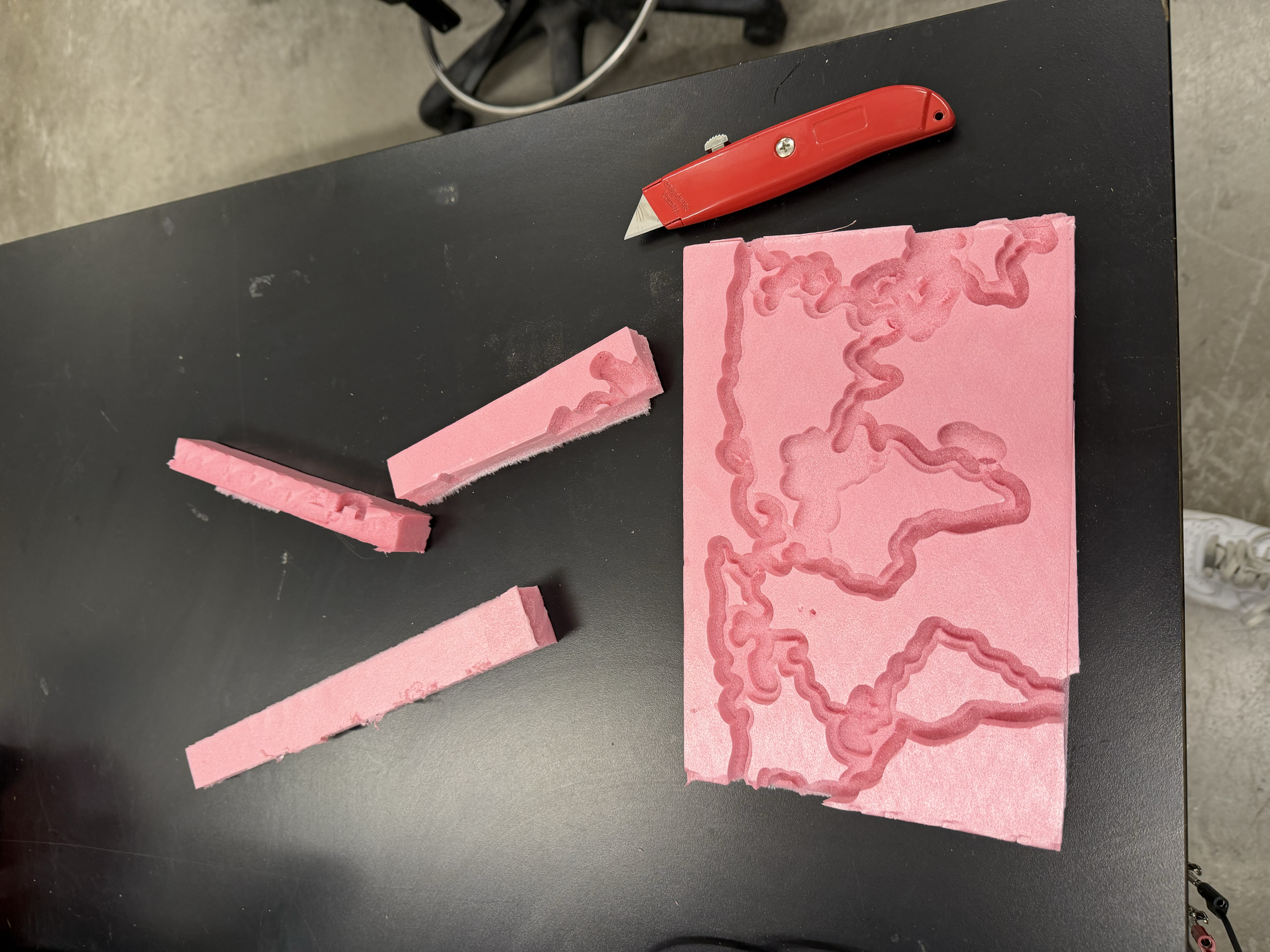 Cutting off some edges of the foam board so that it fits onto the vacuum former