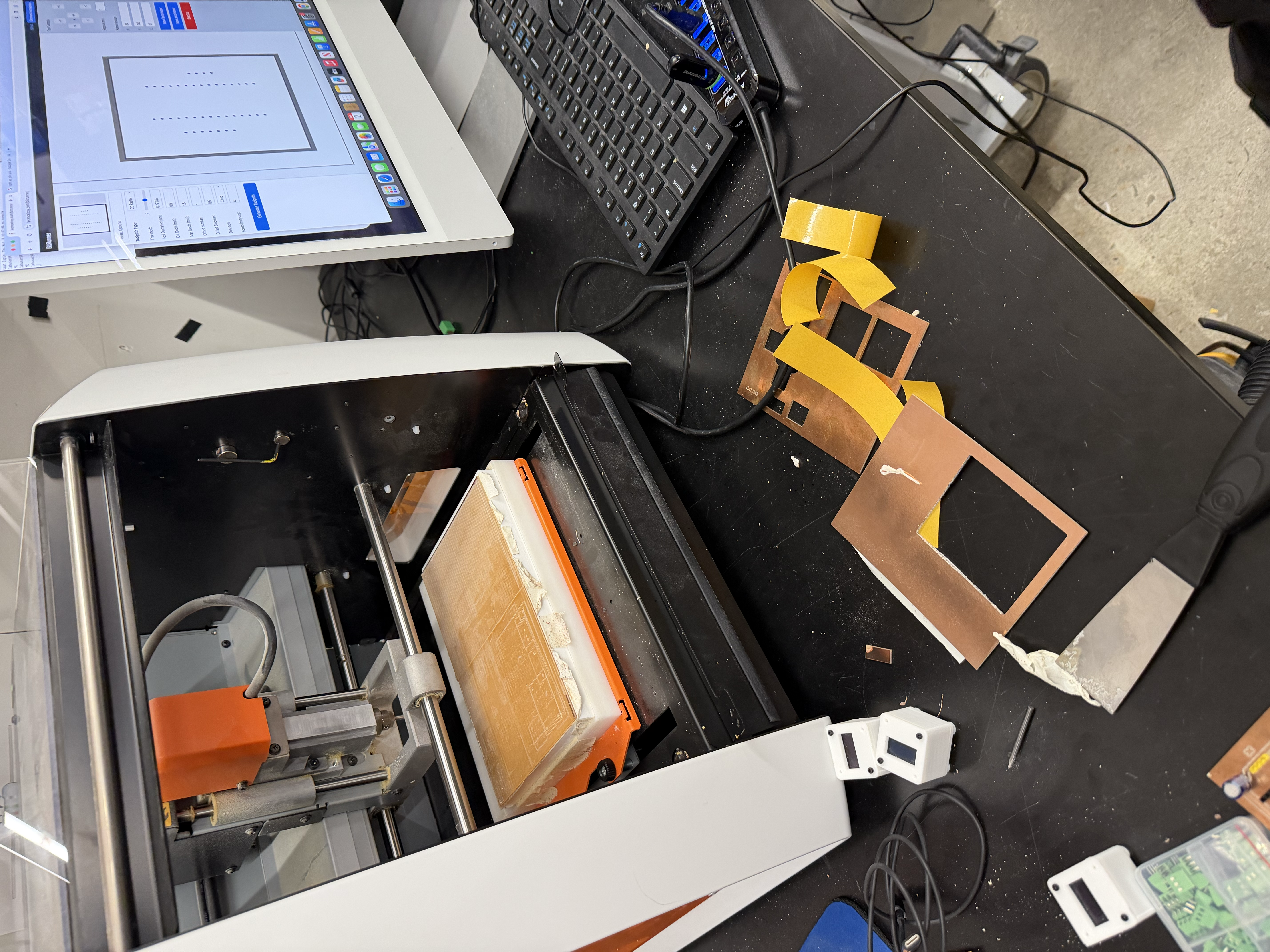 Adding lots and lots of double sided tape onto the board to make it as flat as possible for the CNC