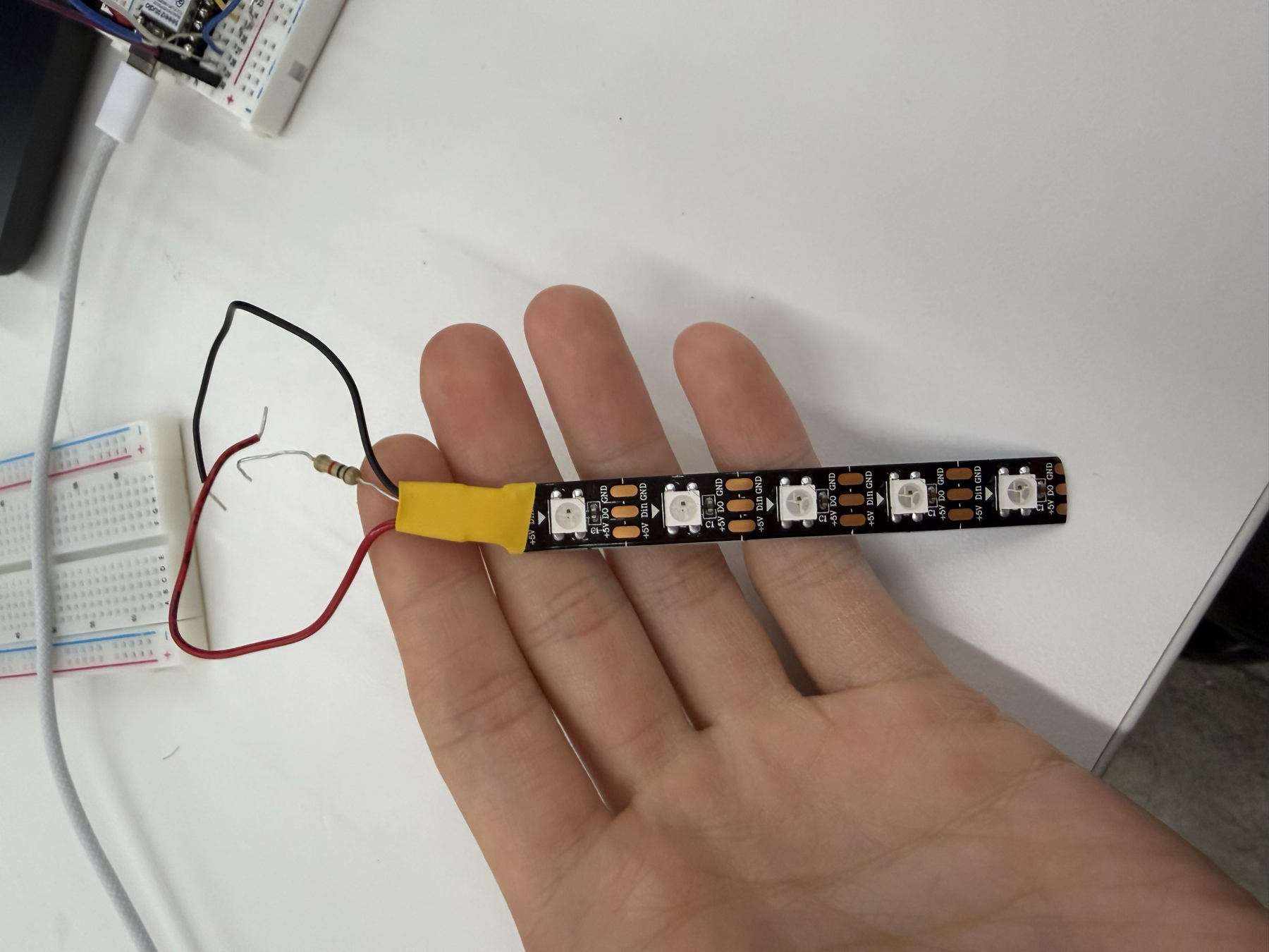 Broken LED strip segment with taped wiring before soldering a working strip