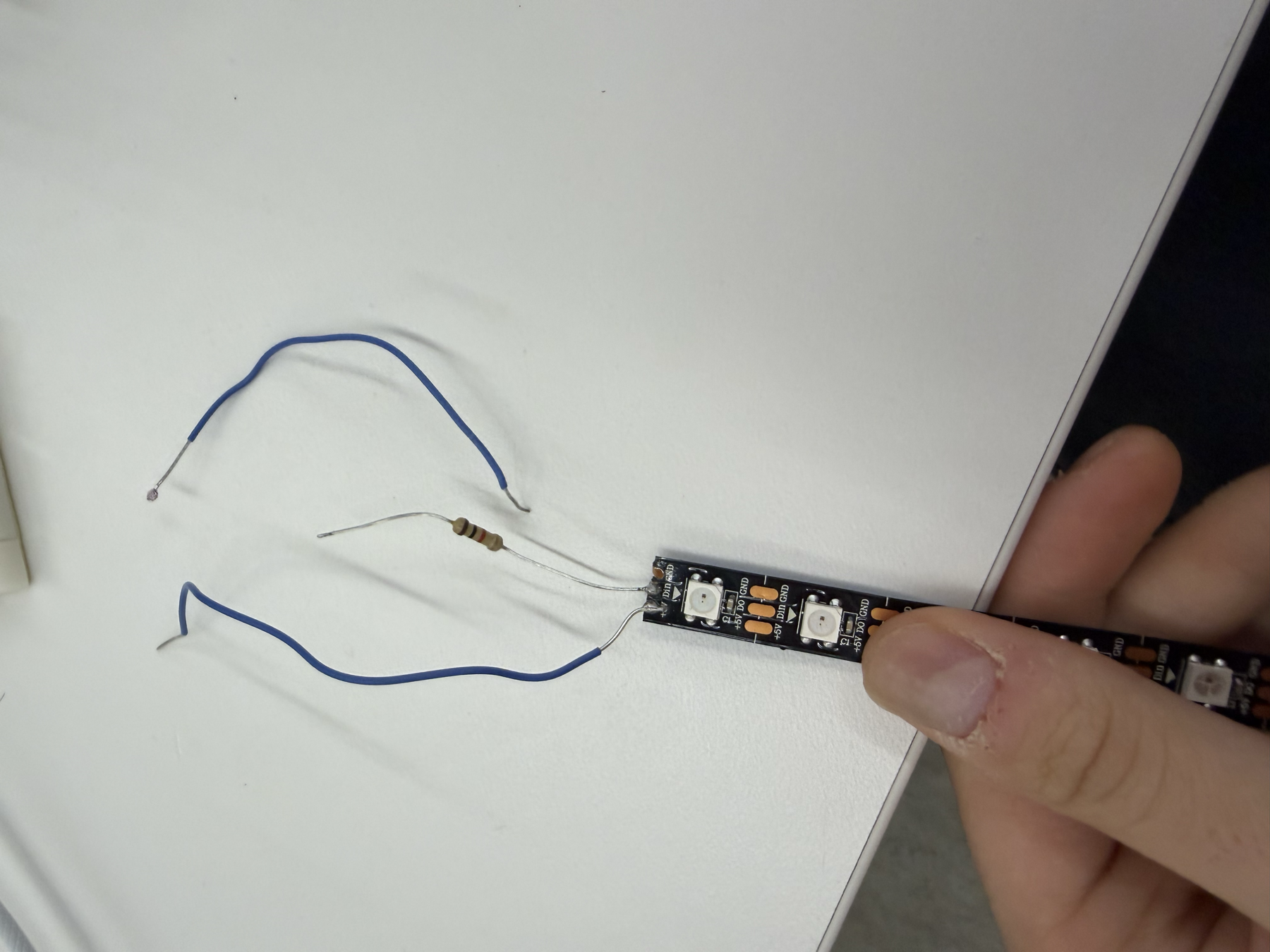 Broken LED strip segment with loose wires before soldering a working strip